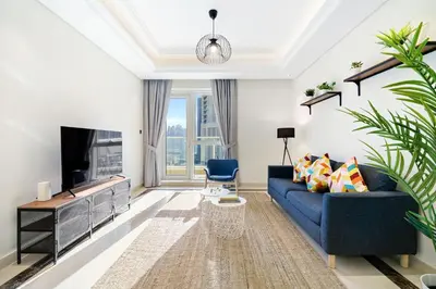 a living room with a blue couch and a tv at Bright & Vibrant 2BR+kids room 7min to Dubai Mall in Dubai