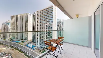 two chairs on a balcony with a view of a city at Majestine Apartments in Dubai