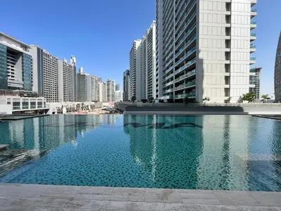 a large pool of water in a city with tall buildings at Majestine Apartments in Dubai