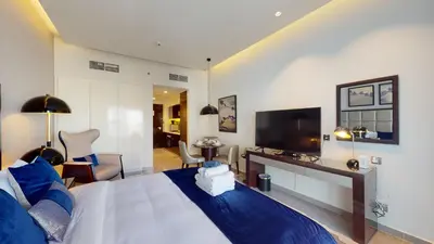 a bedroom with a large bed and a television at Majestine Apartments in Dubai