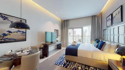 a hotel room with a bed and a desk and a television at Majestine Apartments in Dubai