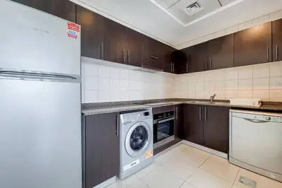 a kitchen with a refrigerator and a washing machine at Bay Central, Dubai Marina - Peaceful One Bedroom in Dubai