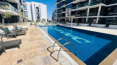 a swimming pool in the middle of a building at Newly Furnished bright and cozy studio apartment - Damac Hills in Dubai