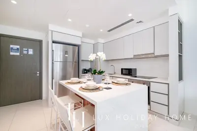 a kitchen with white cabinets and a white counter top at LUX The Luxury Sunrise Beachfront Suite 1 in Dubai