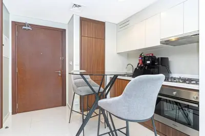 a kitchen with a glass table and two chairs at Skyline 20thModern 1BRIconic Burj Khalifa View in Dubai