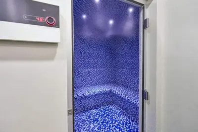 a walk in shower with blue tiles in a room at Skyline 20thModern 1BRIconic Burj Khalifa View in Dubai