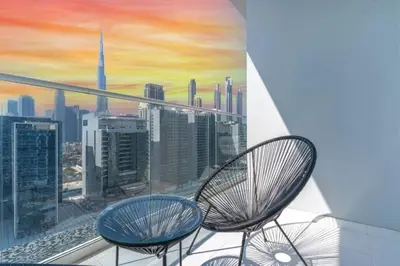 a balcony with two chairs and a view of a city at Skyline 20thModern 1BRIconic Burj Khalifa View in Dubai