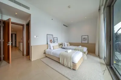 two beds in a room with a window at Luxurious 3BR Maid room 33rd Floor Marina Gate in Dubai