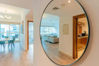 a mirror reflecting a living room and a dining room at Stylish Waterfront 2 Bed in Dubai Marina in Dubai