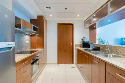 a kitchen with wooden cabinets and a sink at Stylish Waterfront 2 Bed in Dubai Marina in Dubai