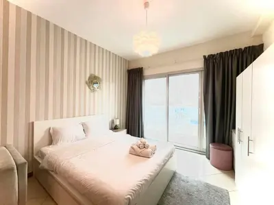 a bedroom with a bed and a large window at Amazing Largest Studio in Marina Next to Metro - Central Location in Dubai