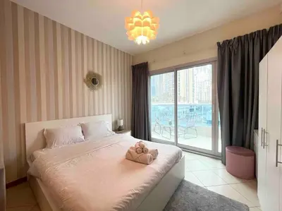 a bedroom with a bed with a teddy bear on it at Amazing Largest Studio in Marina Next to Metro - Central Location in Dubai