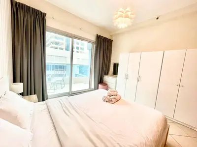 a bedroom with a bed with a teddy bear on it at Amazing Largest Studio in Marina Next to Metro - Central Location in Dubai
