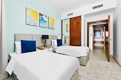 a hotel room with two beds and a mirror at StoneTree - Marina Gate 2 BR - Partial Sea View in Dubai