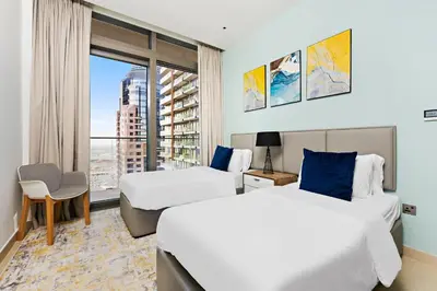 a hotel room with two beds and a window at StoneTree - Marina Gate 2 BR - Partial Sea View in Dubai