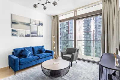 a living room with a blue couch and a chair at StoneTree - Marina Gate 2 BR - Prime location in Dubai