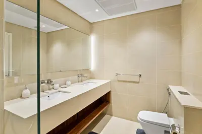a bathroom with a sink and a toilet and a mirror at StoneTree - Marina Gate 2 BR - Prime location in Dubai