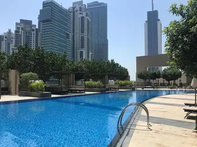 a large swimming pool with a city skyline in the background at Fancy One Bedroom Apartment in Downtown Dubai By ĀYA Boutique in Dubai