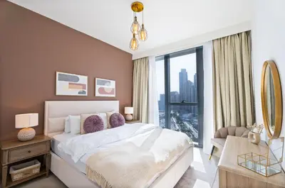 a bedroom with a large bed and a large window at Fancy One Bedroom Apartment in Downtown Dubai By ĀYA Boutique in Dubai