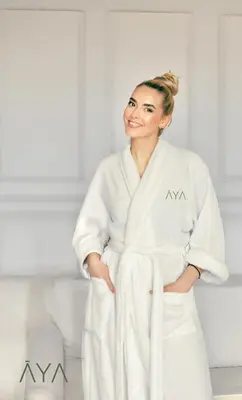 a woman in a white robe standing in a bathroom at Fancy One Bedroom Apartment in Downtown Dubai By ĀYA Boutique in Dubai
