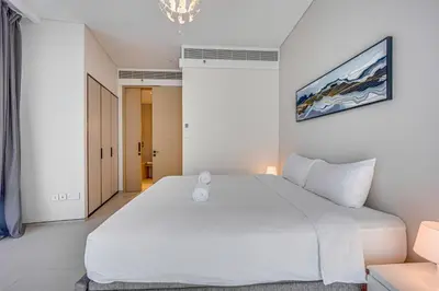 a bedroom with a large white bed and a chandelier at Canal View apartment in Address Beach Residence JBR, the 29th floor, 1BR in Dubai