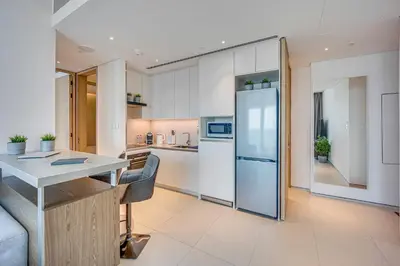 a kitchen with a table and a refrigerator at Canal View apartment in Address Beach Residence JBR, the 29th floor, 1BR in Dubai