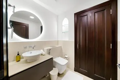 a bathroom with a sink and a toilet and a mirror at Classy Design 2BR in Old Town w/ Burj Khalifa View in Dubai