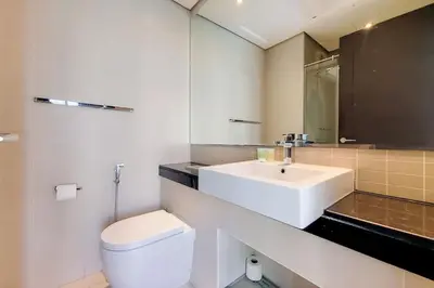 a white bathroom with a sink and a toilet at Vacationer I Elegant 1 Bedroom Apartment I Marina Views I Walk to Marina Mall I Silverene Tower B in Dubai