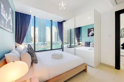 a bedroom with a large bed and a tub and windows at Vacationer I Elegant 1 Bedroom Apartment I Marina Views I Walk to Marina Mall I Silverene Tower B in Dubai