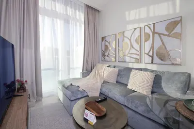 a living room with a blue couch and a table at New Arabian Reva 1BR Burj Khalifa View in Dubai