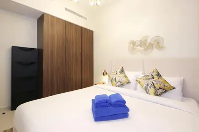 a bedroom with a white bed with blue towels on it at New Arabian Reva 1BR Burj Khalifa View in Dubai