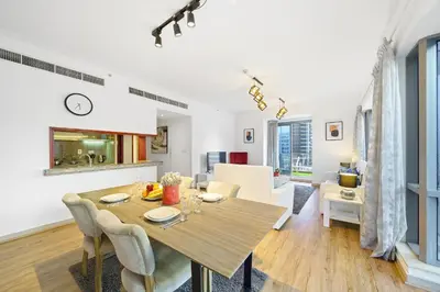 a dining room and living room with a table and chairs at Contemporary & Roomy 2BR with Burj Khalifa view in Dubai