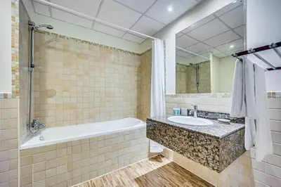 a bathroom with a tub and a sink and a mirror at New sea view Rimal 2BD in front of the beach in Dubai