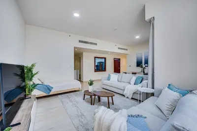 a living room with two white couches and a table at New sea view Rimal 2BD in front of the beach in Dubai