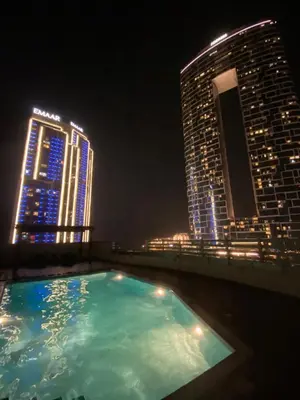 a swimming pool on the roof of a building at night at Stylish 1 BR with sea view - Sunset view in Dubai