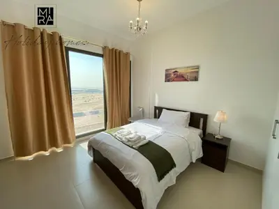 a bedroom with a bed and a large window at Mira Holiday Homes - Serviced Studio in Una Apartment in Dubai