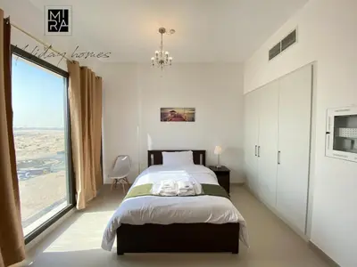 a bedroom with a bed and a large window at Mira Holiday Homes - Serviced Studio in Una Apartment in Dubai
