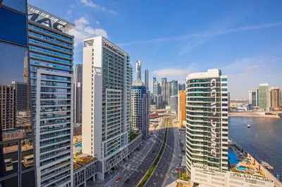 a city skyline with tall buildings and a river at Daniels Canal View 1BR at J One Business Bay in Dubai