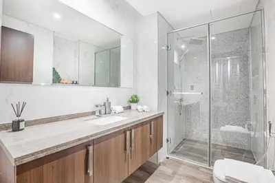 a bathroom with a sink and a glass shower at Daniels Canal View 1BR at J One Business Bay in Dubai