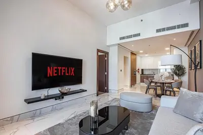 a living room with a television on a wall at Daniels Canal View 1BR at J One Business Bay in Dubai