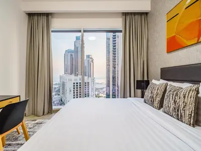 a bedroom with a large bed and a large window at Incredible Waterfront Apt with Panoramic Views in Dubai