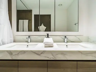 a bathroom with a large marble sink with a mirror at Incredible Waterfront Apt with Panoramic Views in Dubai