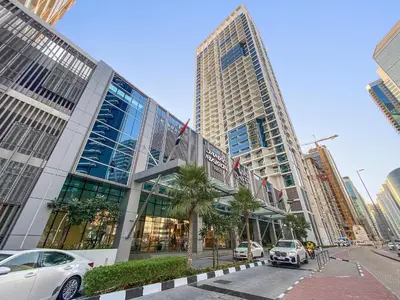 a car is parked in front of a building at Elegant 1BR - Spacious & Luxury - Canal View in Dubai