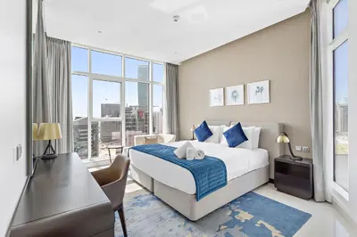 a bedroom with a bed and a large window at Elegant 1BR - Spacious & Luxury - Canal View in Dubai