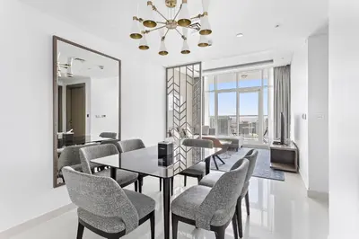 a dining room with a table and chairs and a mirror at Elegant 1BR - Spacious & Luxury - Canal View in Dubai