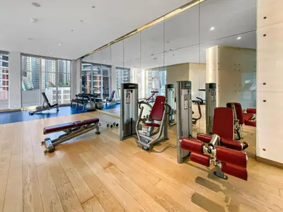 a gym with several treadmills and exercise machines at Elegant 1BR - Spacious & Luxury - Canal View in Dubai