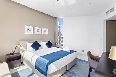 a bedroom with a bed and a table and a desk at Elegant 1BR - Spacious & Luxury - Canal View in Dubai