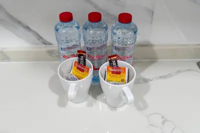 a group of bottles of water and two cups at Nice and cozy Studio Elysée 2 in JVC - Dubai in Dubai