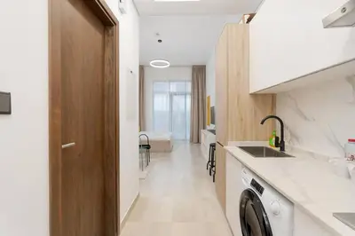 a kitchen with a washer and dryer in a room at Nice and cozy Studio Elysée 2 in JVC - Dubai in Dubai