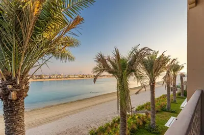 a view of a beach with palm trees at Maison Privee - Exclusive Villa with Private Pool, Garden & Beach in Dubai